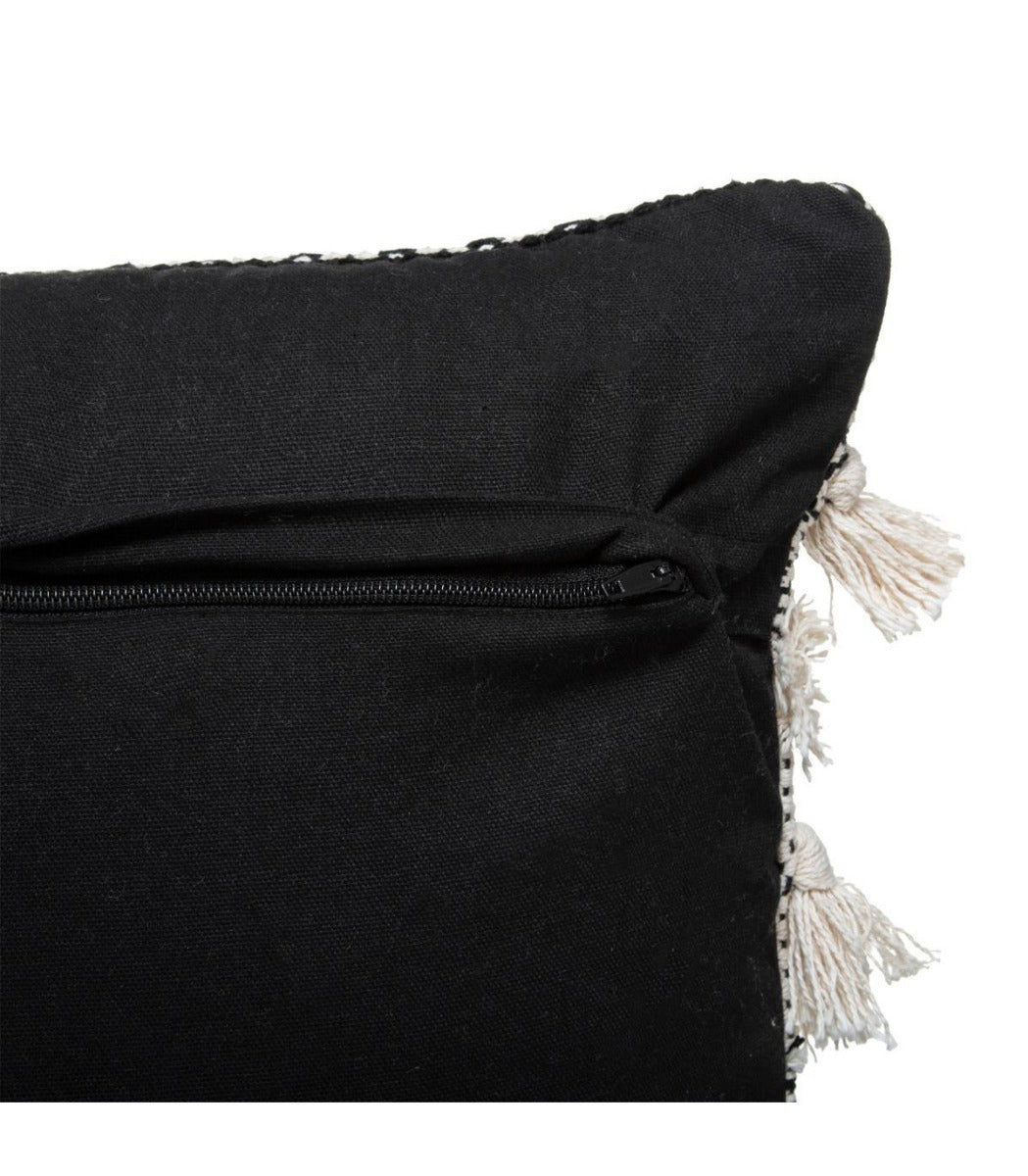Coussin blanc et noir à motif en relief avec pompons
